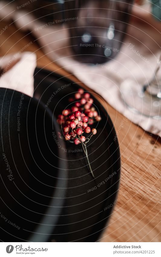 Bunch of decorative berries on served table in cafeteria setting creative design berry festive occasion plate bowl bundle small round shape bunch stem thin