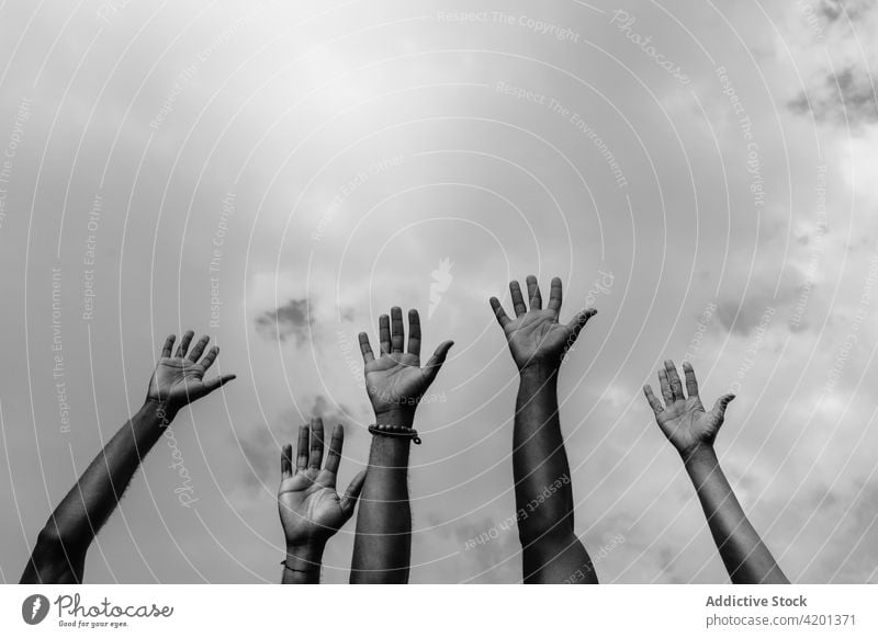 Crop black BLM activists with hands up under cloudy sky hand up black lives matter racism justice social right movement democracy together arms raised sjw blm