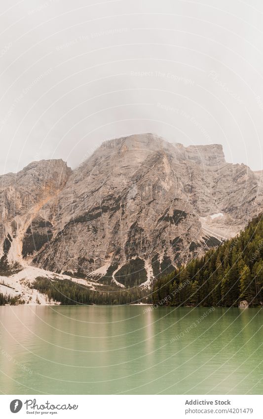 Rocky mountain and lake landscape rock range nature peak fog rough highland majestic dolomites italy water travel tourism ridge picturesque scenic scenery shore