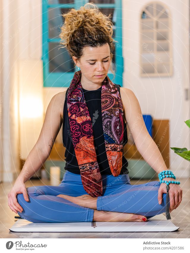 Woman meditating during yoga practice woman asana half lotus zen female mindfulness activewear mat wellbeing studio wellness peaceful meditate spirit sit