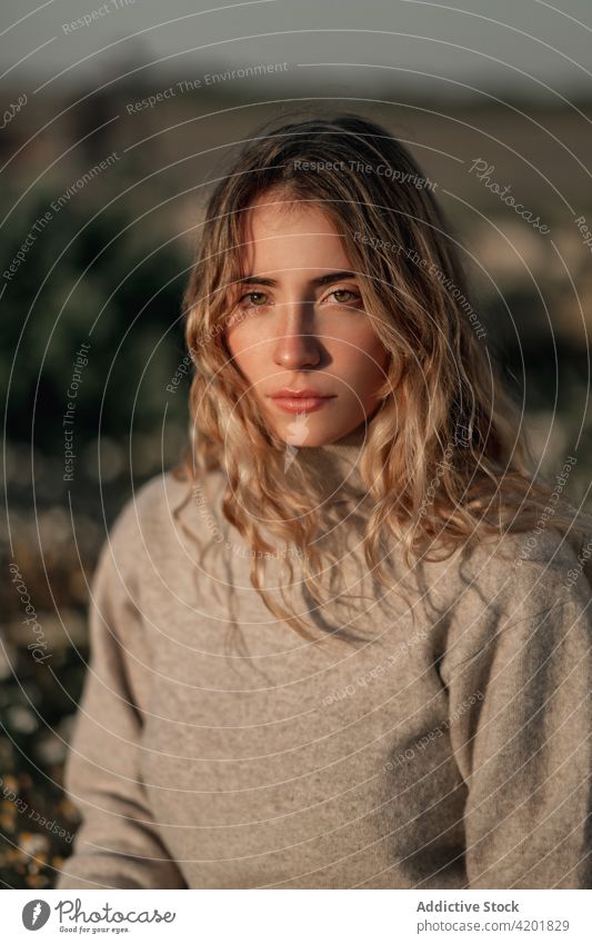 Thoughtful woman sitting in spring field contemplate thoughtful calm traveler nature pensive rest relax environment female young alone countryside lifestyle