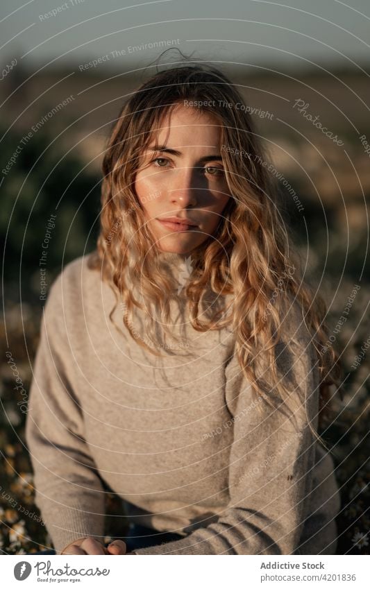 Thoughtful woman sitting in spring field contemplate thoughtful calm traveler nature pensive rest relax environment female young alone countryside lifestyle