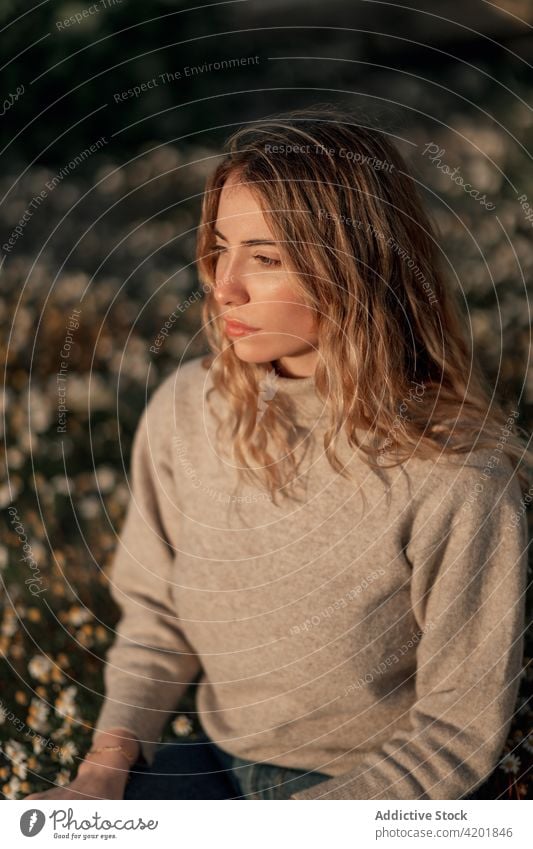 Thoughtful woman sitting in spring field contemplate thoughtful calm traveler nature pensive rest relax environment female young alone countryside lifestyle