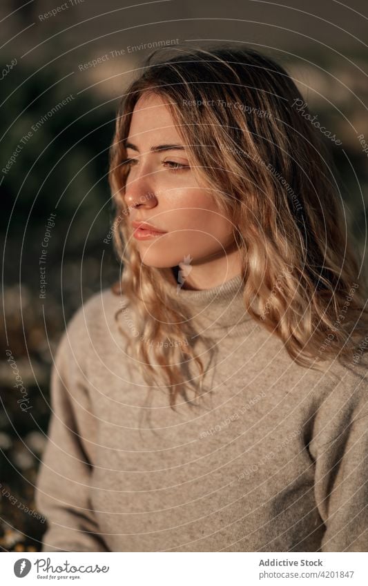 Thoughtful woman sitting in spring field contemplate thoughtful calm traveler nature pensive rest relax environment female young alone countryside lifestyle