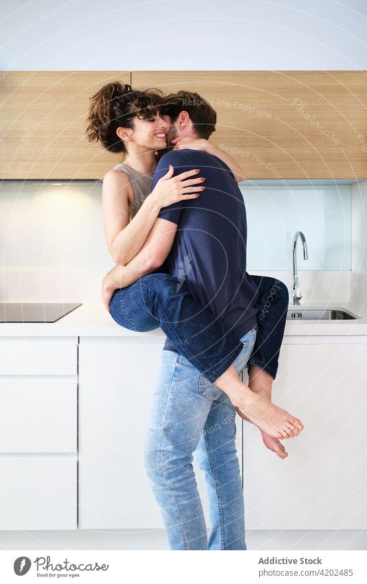 Couple embraced in kitchen on counter couple hug love relationship boyfriend girlfriend romantic young casual light together affection tender shirtless fondness