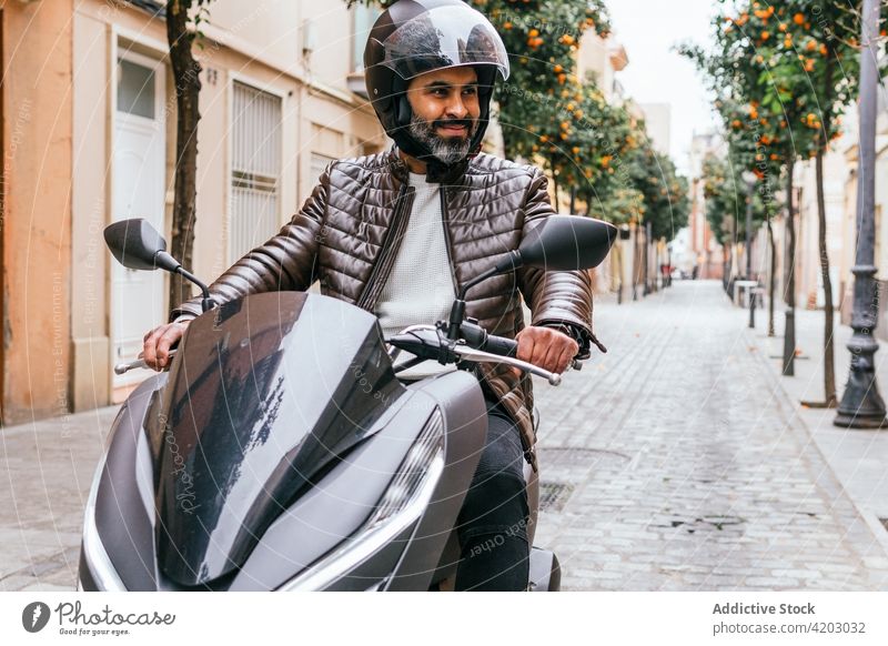 Hispanic motorcyclist driving modern bike on city street biker drive motorbike brutal masculine macho serious man portrait helmet motorcycle style hispanic