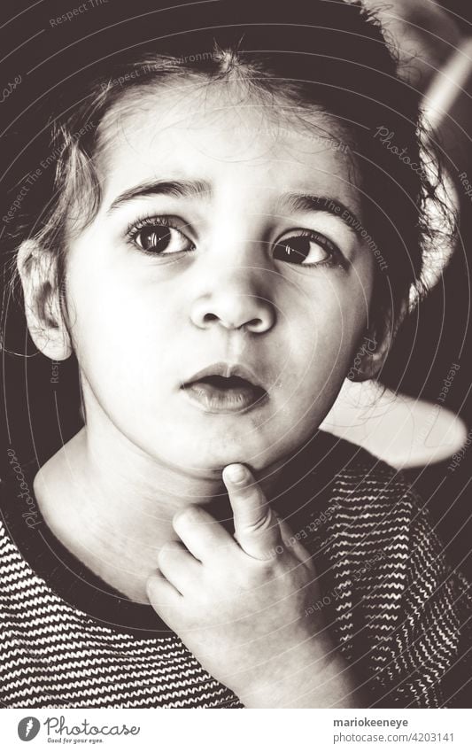 Black and white portrait of a Caucasian little girl in a pensive attitude individuality innocence black and white serene tranquility contemplation loneliness