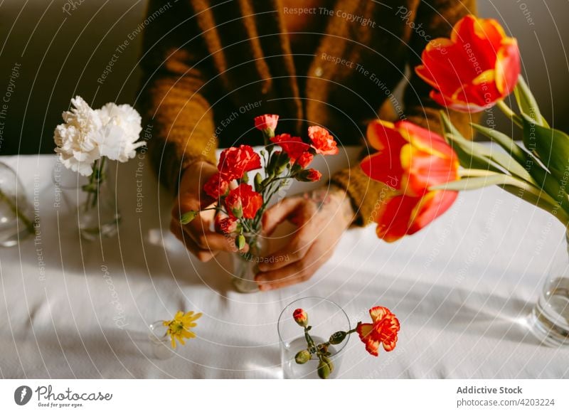 Man with bouquets of fresh bright flowers sitting at table man florist bloom carnation tulip glassware holiday blossom male floral floristry plant aroma event