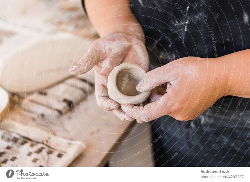 Faceless ceramist shaping clay vessel in studio woman master artisan handwork skill craftswoman earthenware workshop small business female professional