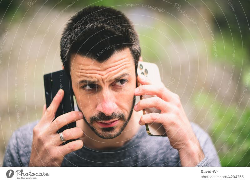 Conference call via smartphone Cellphone make a phone call multitasking Man conversation two Mobile phones conference call