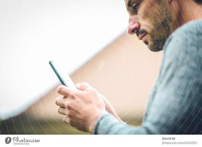 Man uses a cell phone Cellphone Typing Internet Mobile smartphone hands Digital message Face Reading Online