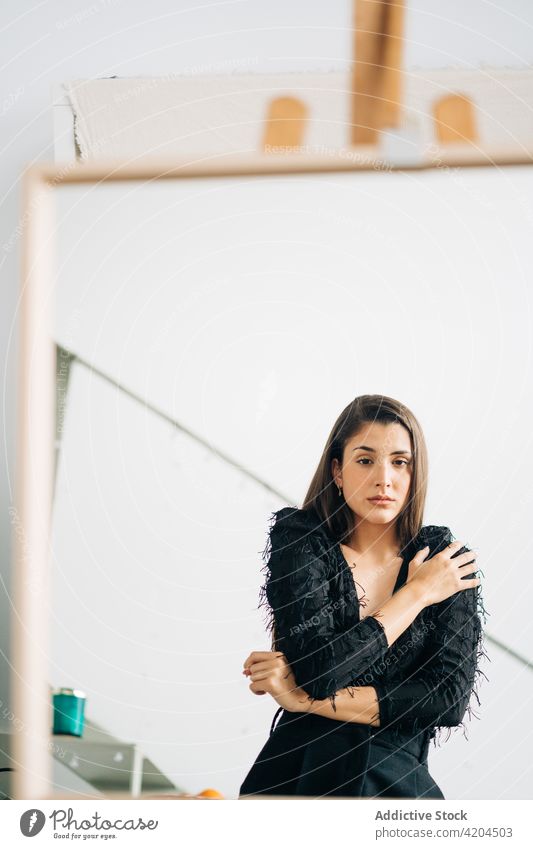 Wistful woman reflecting in mirror on easel reflection wistful art feminine gentle sensitive alone charming earring romantic dreamy accessory modern style