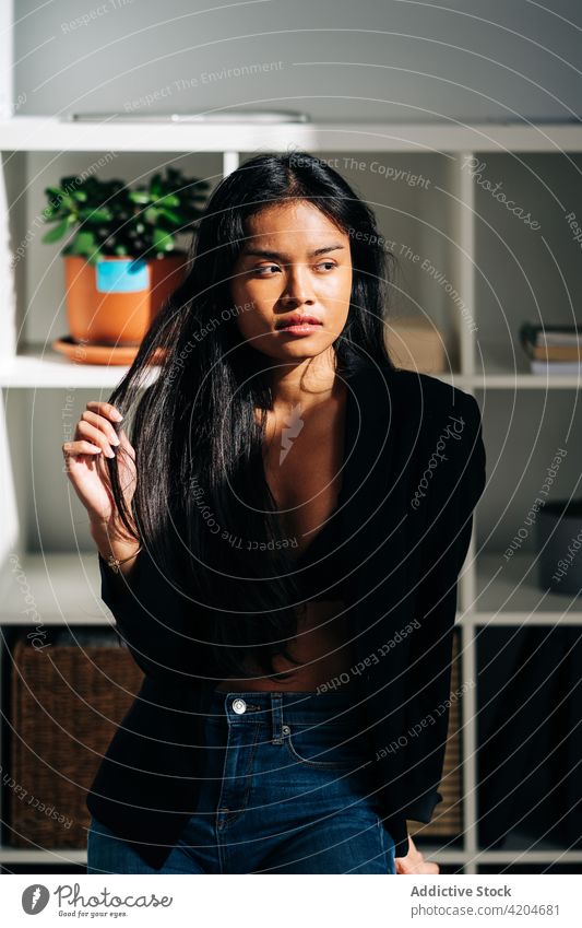 Hispanic woman sitting on chair in apartment feminine friendly room light modern female hispanic emotionless attractive positive brunette contemporary confident