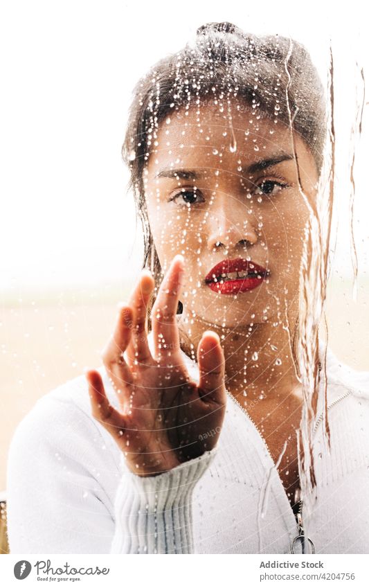 Serious woman touching drops on glass ponder red lips wistful thoughtful calm pensive bright female vivid young appearance confident focus attractive