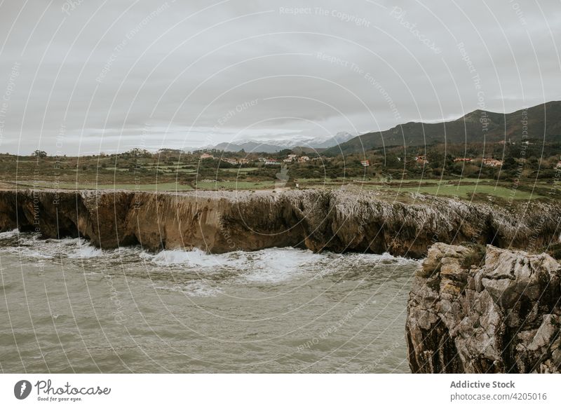 Scenic view of cliff near sea on cloudy day landscape rocky overcast scenery nature seascape shore sky weather wave water coast picturesque breathtaking