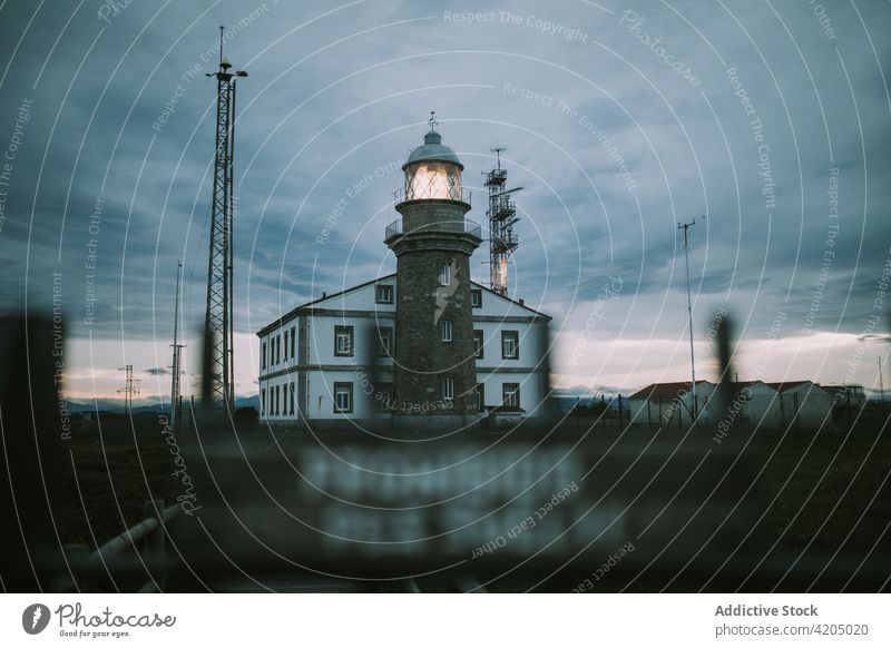 Old lighthouse against cloudy sky in evening beacon sunset tower building navigate twilight sundown dusk illuminate construction glow stone breathtaking scenic