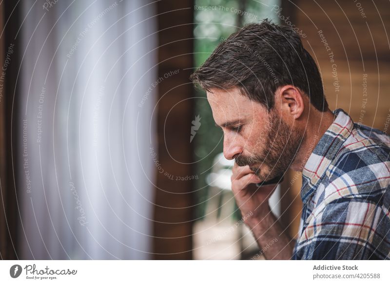 Serious male architect talking on smartphone during remote work blueprint man project sketch discuss speak busy paper plan home drawing serious concentrate