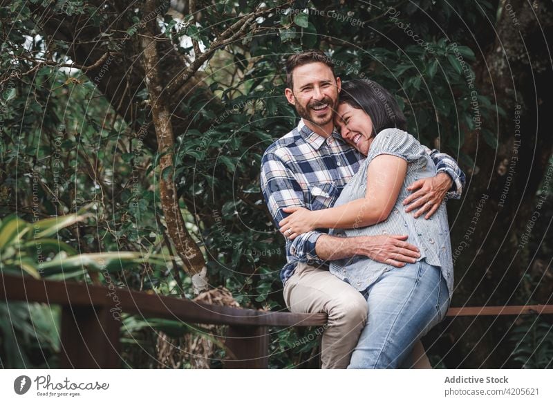 Happy couple hugging on terrace of house in forest laugh embrace cheerful love wooden romantic together happy woods bonding nature relationship close valentine