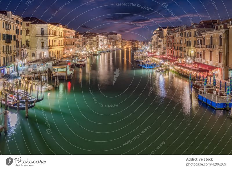 Water channel between buildings in night city grand canal water dark residential scenery venice italy shabby old exterior architecture illuminate light glow sky