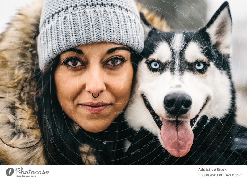 Woman hugging dog in winter forest woman husky happy owner pet female young puppy obedient snow warm clothes loyal animal tree embrace woodland cute purebred