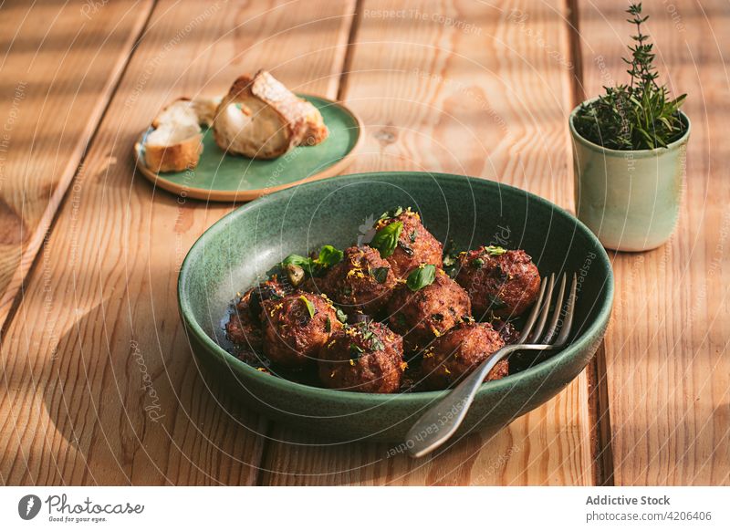 Closeup of a plate of meatloaf with some parsley cooked meatballs culture table menu stuffed stewed roast creamy sauce black olives capers sun dried tomatoes