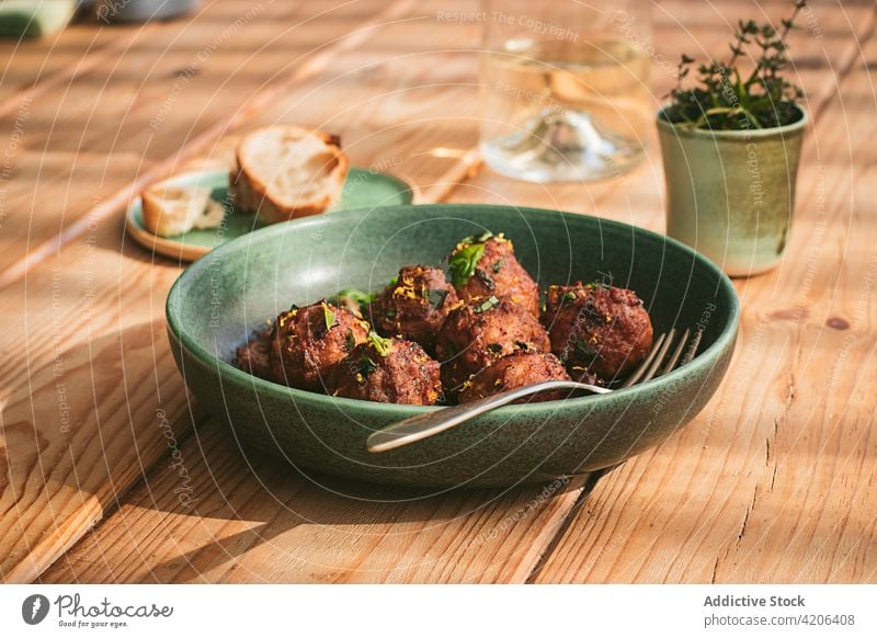 Closeup of a plate of meatloaf with some parsley cooked meatballs culture table menu stuffed stewed roast creamy sauce black olives capers sun dried tomatoes