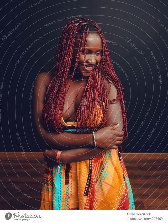 Content black woman with braids in studio hairstyle cheerful appearance beauty complexion long hair pink hair smile female ethnic african american happy joy