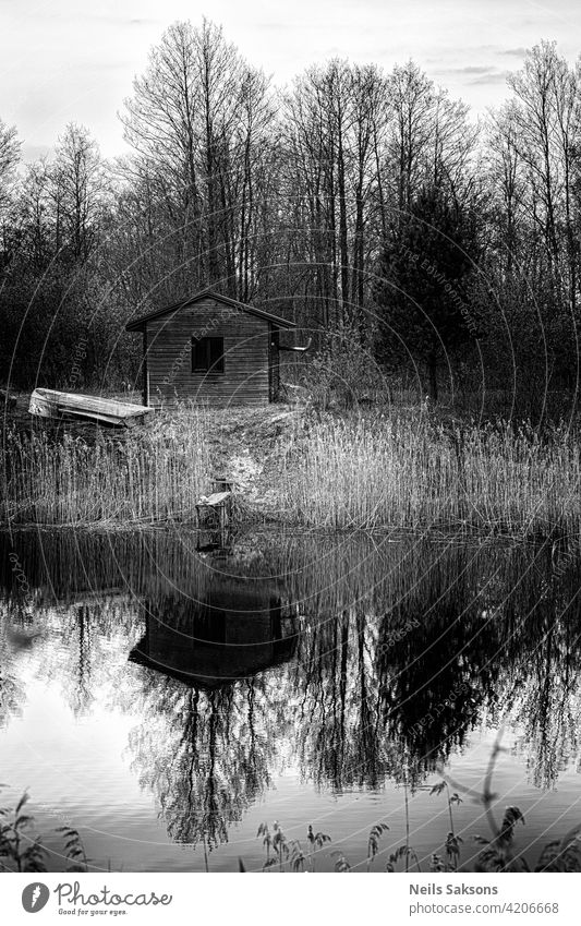 fishermans cabin and boat on ponds shore. Perfect reflection on calm water. lake house landscape nature river tree autumn trees rural park cottage spring