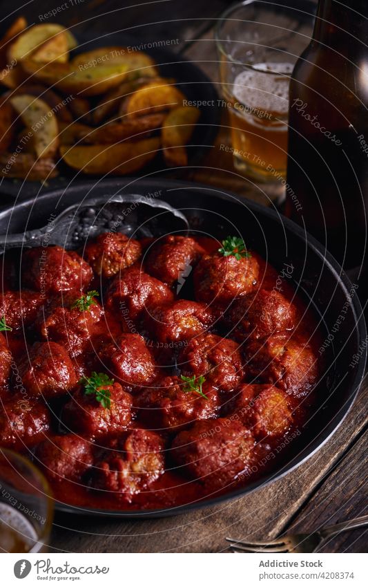 Closeup viewed from above of a plate of meatloaf with tomato meatballs dinner food parsley beef sauce homemade red traditional lunch meal tasty rustic delicious