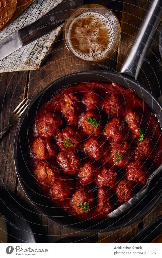 Closeup viewed from above of a plate of meatloaf with tomato meatballs dinner food parsley beef sauce homemade red traditional lunch meal tasty rustic delicious