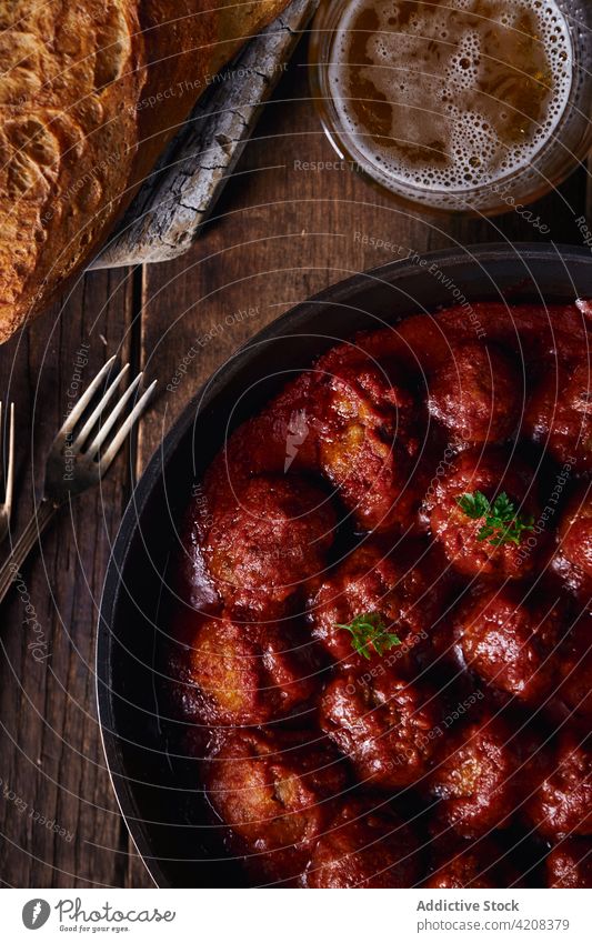 Closeup viewed from above of a plate of meatloaf with tomato meatballs dinner food parsley beef sauce homemade red traditional lunch meal tasty rustic delicious