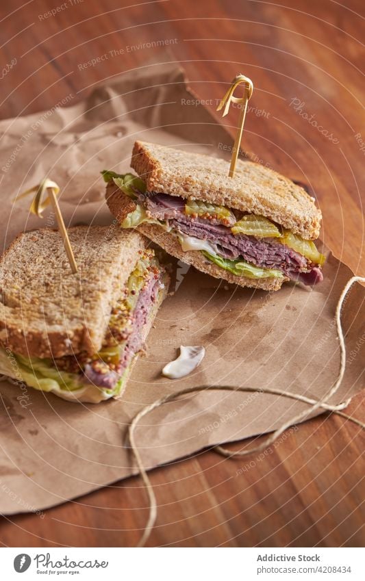 Closeup of a delicious pastrami, lettuce, ham and pickle sandwich lunch cheese bread meat food snack beef fast background tasty dinner american grilled salad