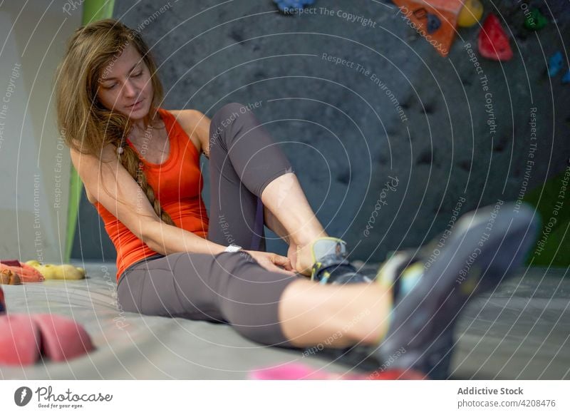 Young sportswoman preparing for climbing wall alpinist shoe prepare uniform sportswear athlete ready concentrate fit focus bouldering strength gym training