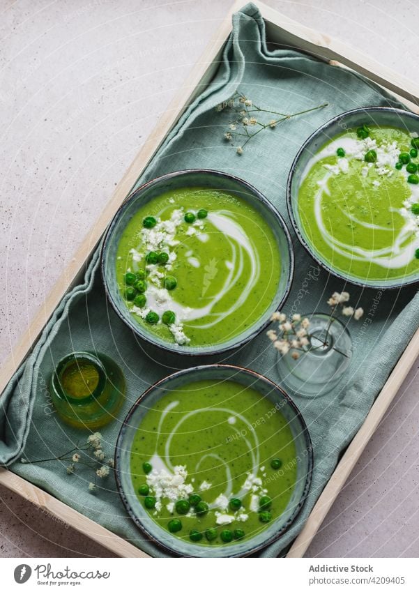 Tasty pea soup in bowls on table cream green delicious serve dish fresh organic tasty food meal gourmet healthy healthy food vegetarian vegan napkin vase flower