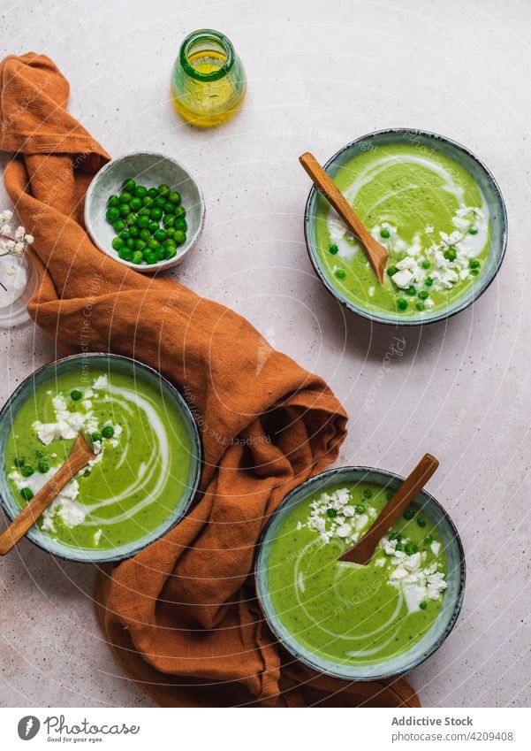 Tasty pea soup in bowls on table cream green delicious serve dish fresh organic tasty food meal gourmet healthy healthy food vegetarian vegan napkin vase flower