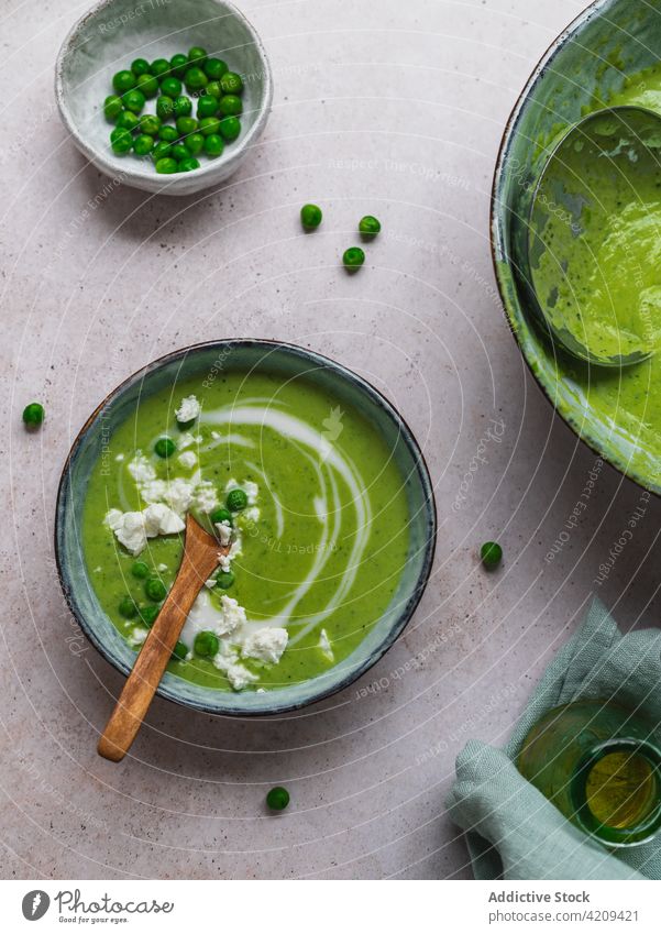 Tasty pea soup in bowls on table cream green delicious serve dish fresh organic tasty food meal gourmet healthy healthy food vegetarian vegan napkin vase puree