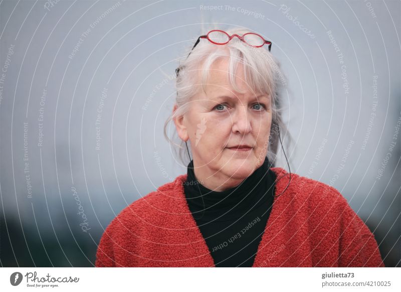 Portrait of a sympathetic older woman with white hair and glasses on her head portrait Central perspective Shallow depth of field blurriness Shadow Light Day