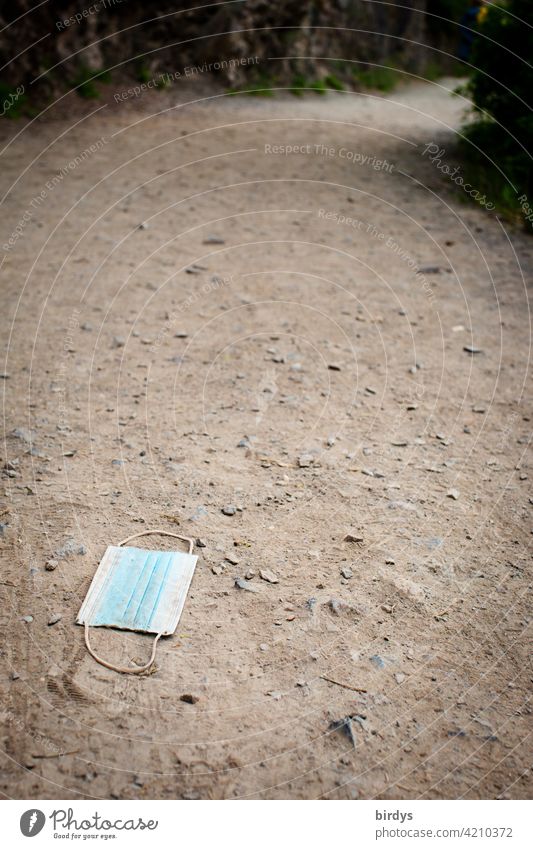 discarded surgical mask on a hiking trail. Pollution with mouth/nose mask. Corona op-mask mouth-nose protection corona Mask Trash carelessness jettisoned