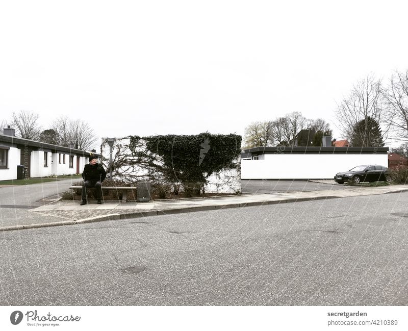 There is always something going on in Nortorf. Small Town void Street Pavement Bench Man masculine by oneself Lonely Exterior shot square Loneliness sad unhappy