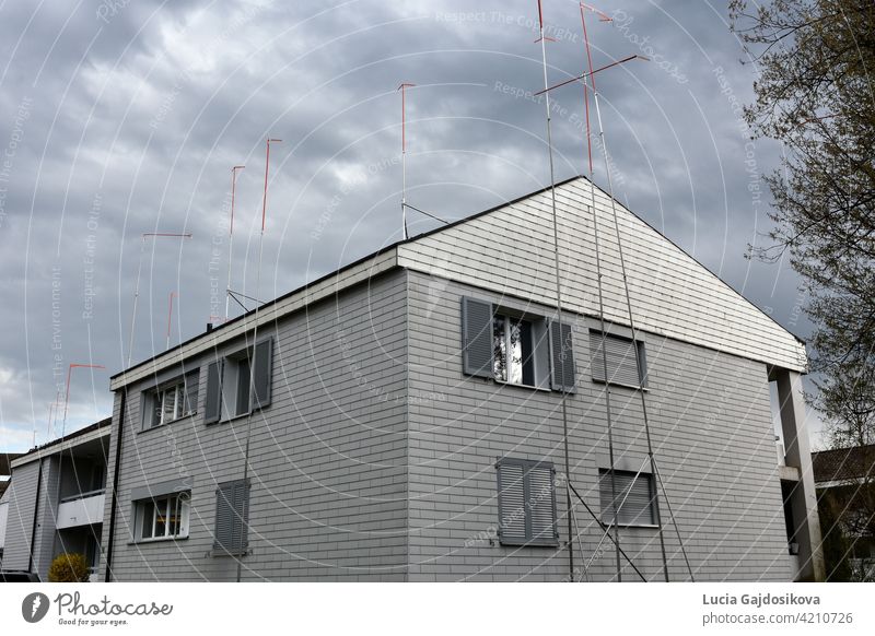 House with metal poles around. They suggest a new shape the house that is going to be rebuilt. Compulsory part of building procedure in Switzerland so that the neighbors can bring objections.