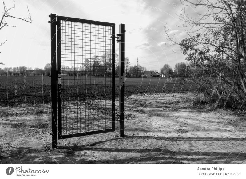 only one locked door, without fence or other demarcation Black & white photo Exterior shot Deserted Day Shadow Contrast Light Sunlight Gloomy Sky Earth