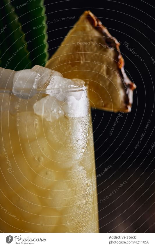 Cocktail glass with pineapple piece and straw on table cocktail ice leaf drink beverage tasty decoration appetizing fruit alcohol tropical yummy pub glassware