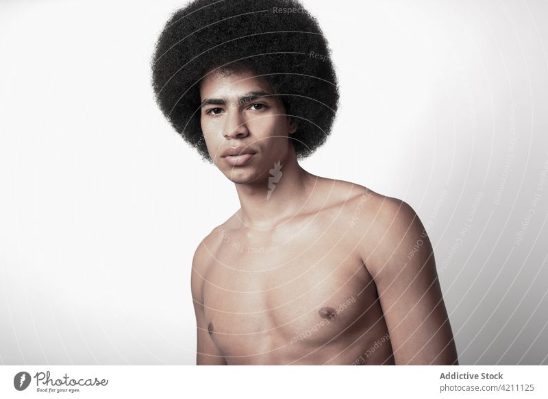 Masculine African American model with naked torso six pack masculine macho confident afro hairstyle man portrait fit shirtless self assured individuality cool