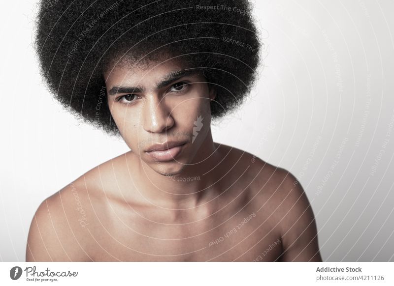 Masculine African American model with naked torso six pack masculine macho confident afro hairstyle man portrait fit shirtless self assured individuality cool