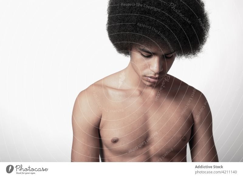 Masculine African American model with naked torso six pack masculine macho confident afro hairstyle man portrait fit shirtless self assured individuality cool