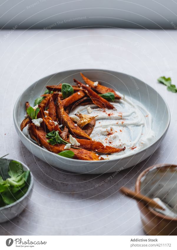 Sweet potato fries in bowl on table sweet baked crispy serve herb tasty food snack appetizing appetizer sour cream meal yummy portion delicious palatable