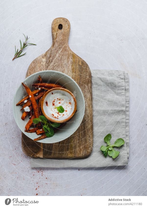 Sweet potato fries in bowl on table sweet baked crispy serve herb tasty food snack appetizing appetizer sour cream meal yummy portion delicious palatable