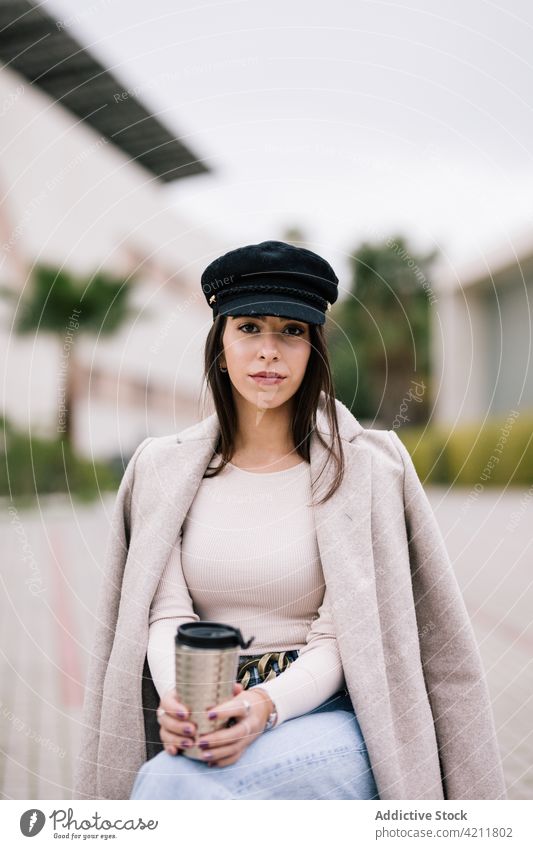 Businesswoman sitting on bench with takeaway coffee in cup businesswoman city trendy entrepreneur to go female outfit beverage drink hot drink street urban