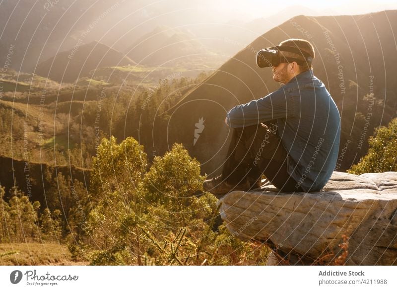 Traveler experiencing virtual reality in goggles in mountains traveler vr headset man experience interact explore male device technology entertain glasses