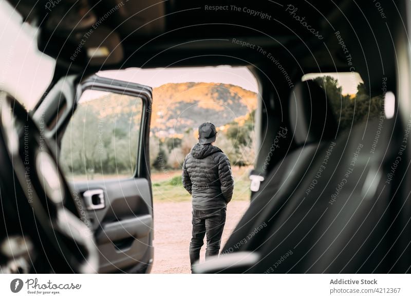 Adventurous man contemplating the landscape next to his car adventure vehicle transportation 4wd traveler adventurer jeep copy space 4x4 green journey nature